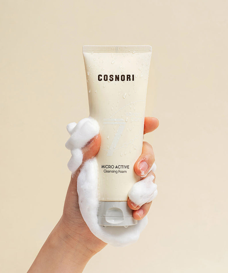 COSNORI Micro Active Cleansing Foam 150ml 2ea, tube beige tenu main, mousse sur peau, contexte visuel beauté
