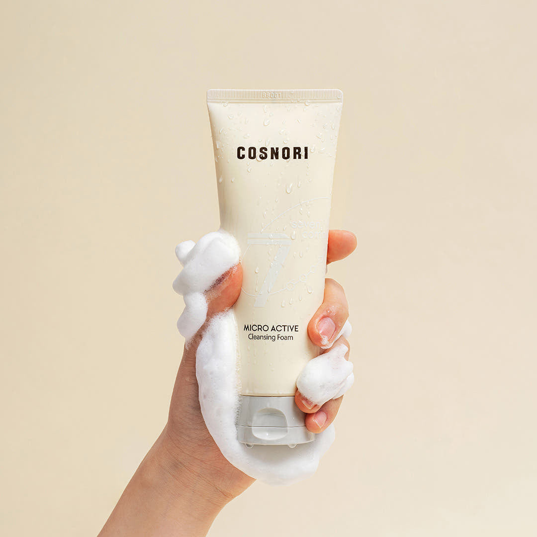 COSNORI Micro Active Cleansing Foam 150ml 2ea, tube beige tenu main, mousse sur peau, contexte visuel beauté