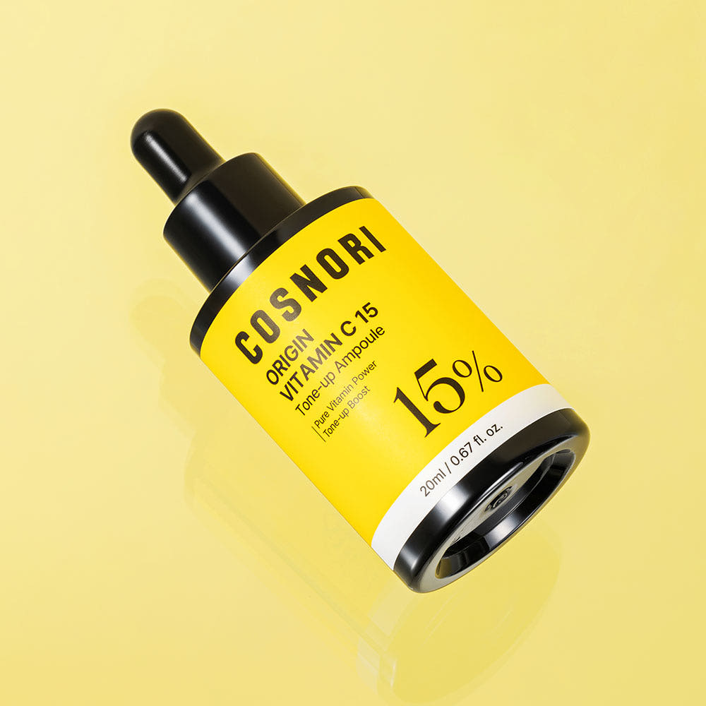 COSNORI Origin Vitamin C 15 Tone-Up Ampoule 20ml, marque COSNORI, flacon jaune sur fond pastel, contexte beauté.