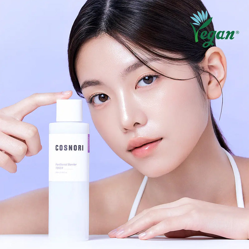 COSNORI Panthenol Barrier Toner 205ml de la marque COSNORI : femme à la main tenant le flacon, fond bleu pastel.