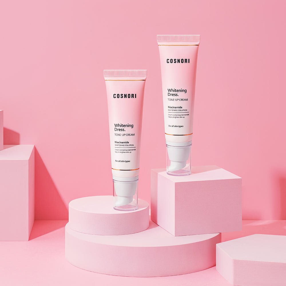 COSNORI Whitening Dress Tone-Up Cream 50ml, packshots sur podiums roses, crème éclaircissante de la marque COSNORI
