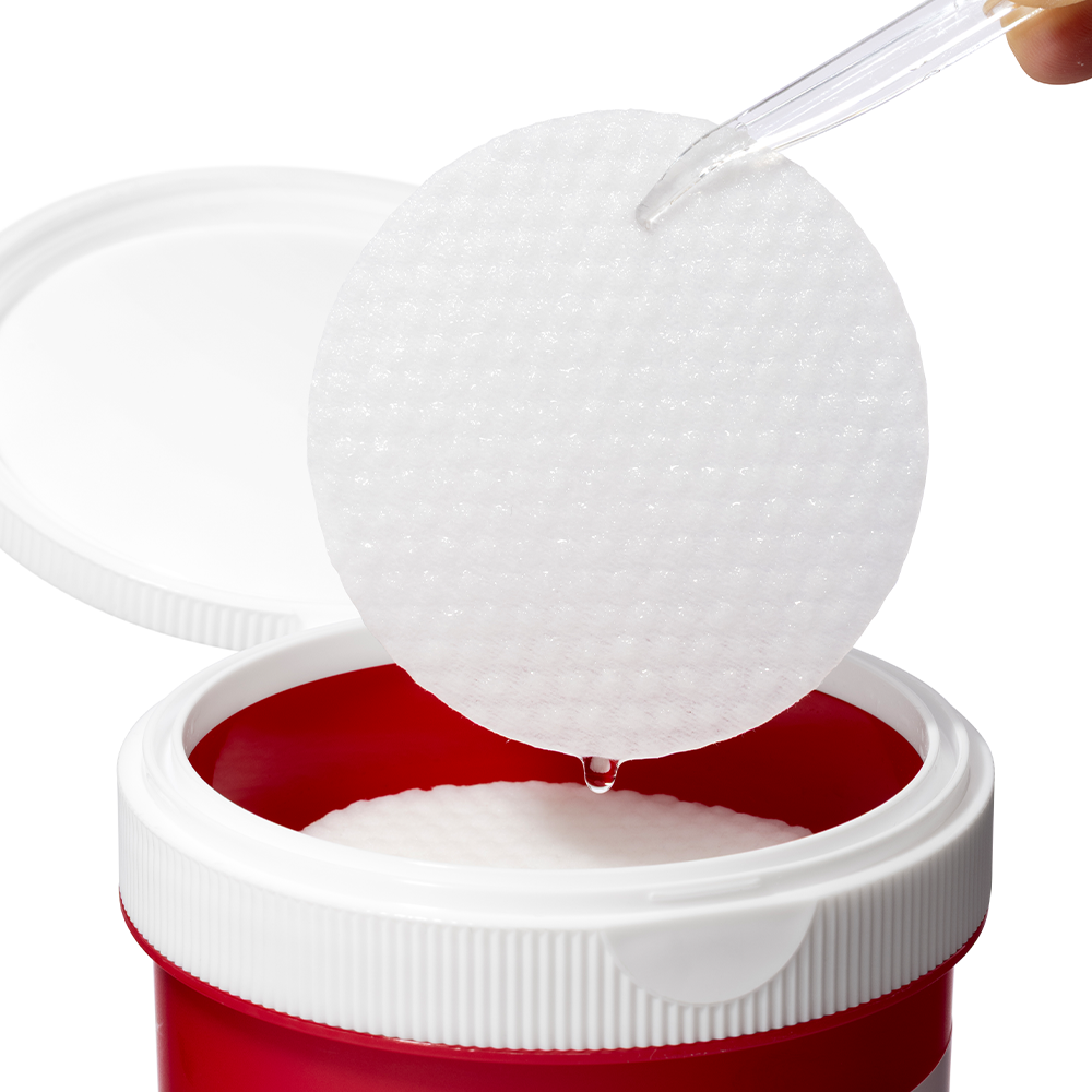 COSRX One Step Original Blemish Pore Clear Pads 100 Sheets : pad blanc ouvert sur pot rouge, vue rapprochée, face cosmétique