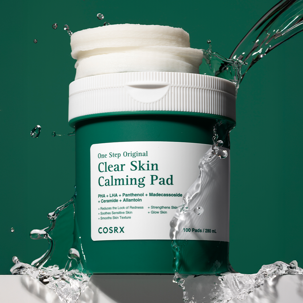 COSRX One-Step Original Clear Skin Calming Pads (100 sheets) de COSRX, pot blanc avec eau éclaboussures, fond vert