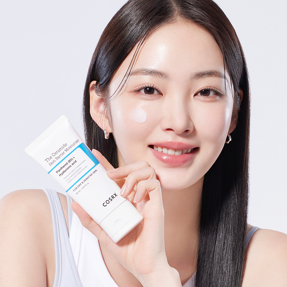 COSRX The Ceramide Skin Barrier Moisturizer : la femme présente le produit, packaging blanc, contexte skincare sur fond clair.