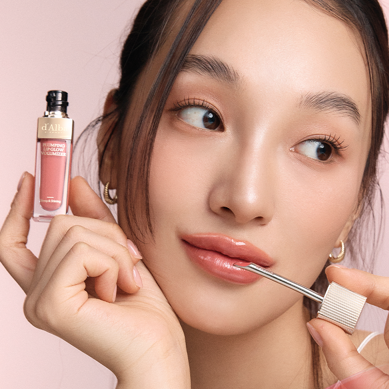 D'ALBA Plumbing Lip Glow Mood Volumizer, photo maquillage, marque D'ALBA et tube tenu, lèvres brillantes, fond rose