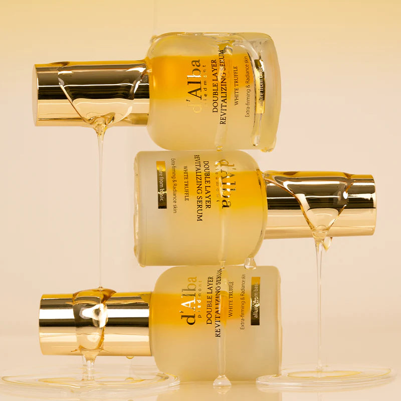 Décris l'image en français : D'ALBA Vegan Double Serum 30ml de la marque D'Alba, flacons dorés sur fond beige.