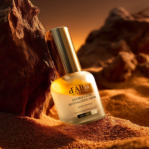 D'ALBA Vegan Double Serum 30ml de la marque D'ALBA, flacon doré sur sable et roche au coucher du soleil