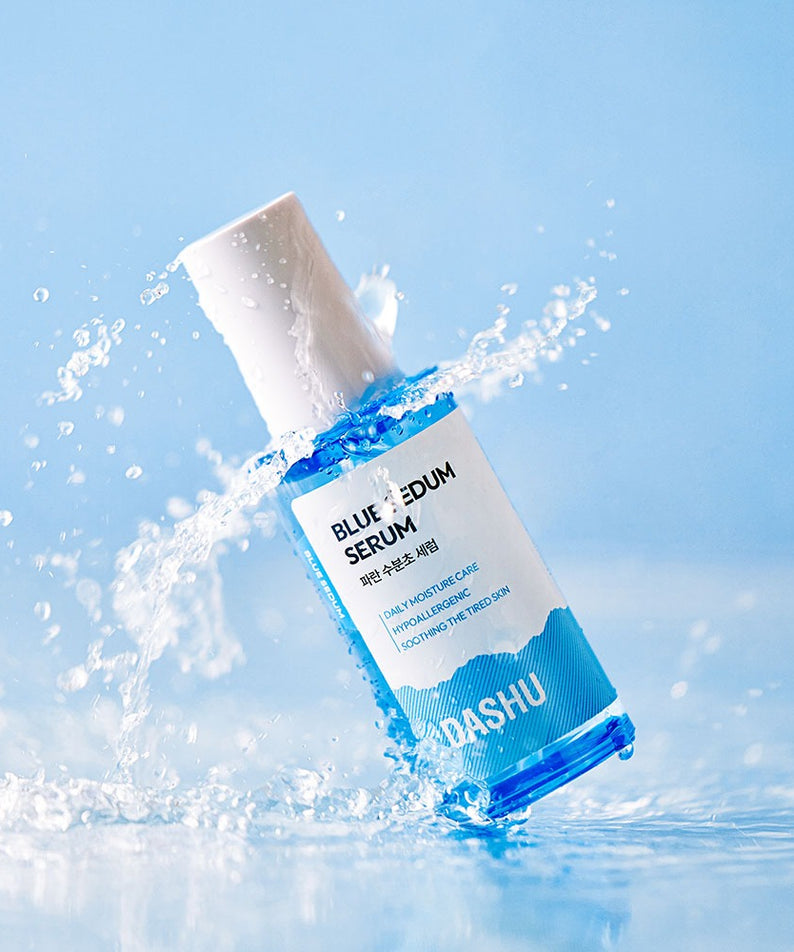 DASHU Boy Blue Moisture Serum 65ml, flacon bleu DASHU projeté dans l’eau avec éclaboussures, fond bleu