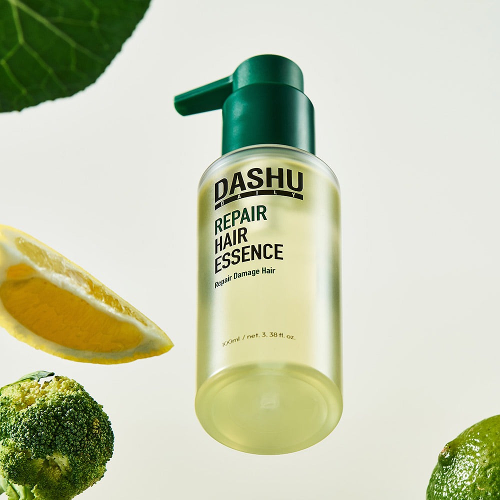 DASHU Daily Repair Hair Essence 100ml, flacon vert avec marque DASHU sur fond blanc, feuilles et gouttes, visuel beauté.