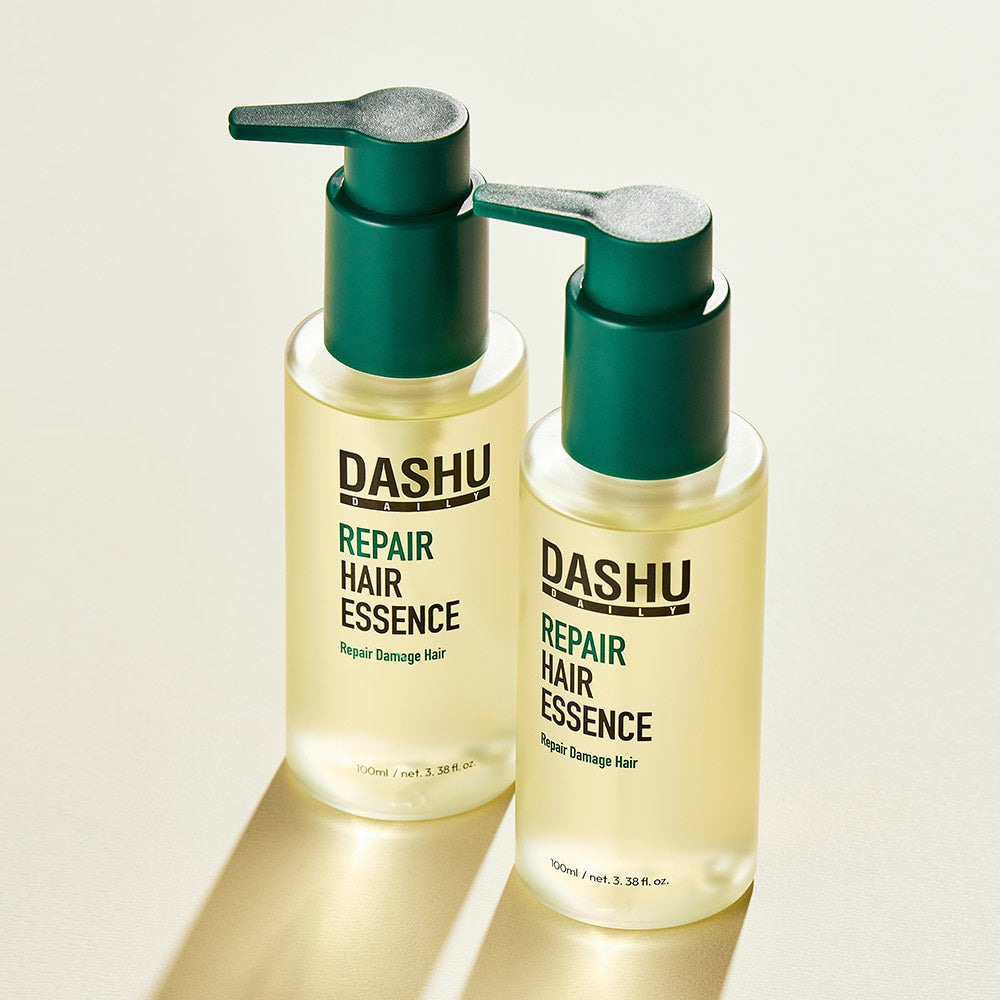 DASHU Daily Repair Hair Essence 100ml, flacons verts et transparents, fond clair studio, produit de marque DASHU pour cheveux