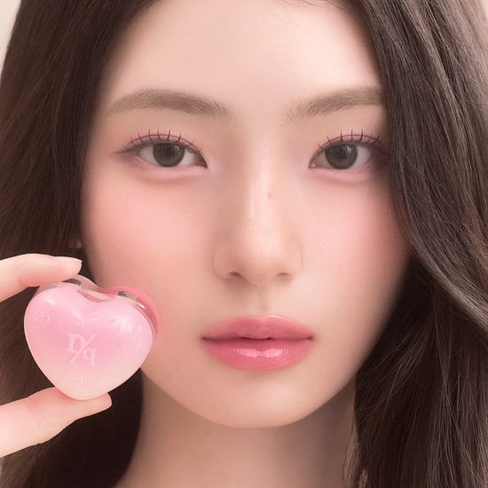 DASIQUE Daisy Candy Rolling Pot de la marque DASIQUE, pot rose en forme de cœur, maquillage sur fond noir