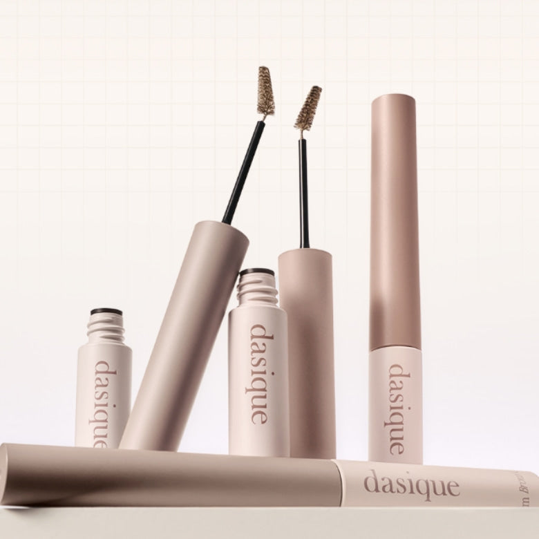 DASIQUE Pro Slim Brow Cara 6 colors, brosses à sourcils en gamme de teintes, sur fond beige et flacons parasol.