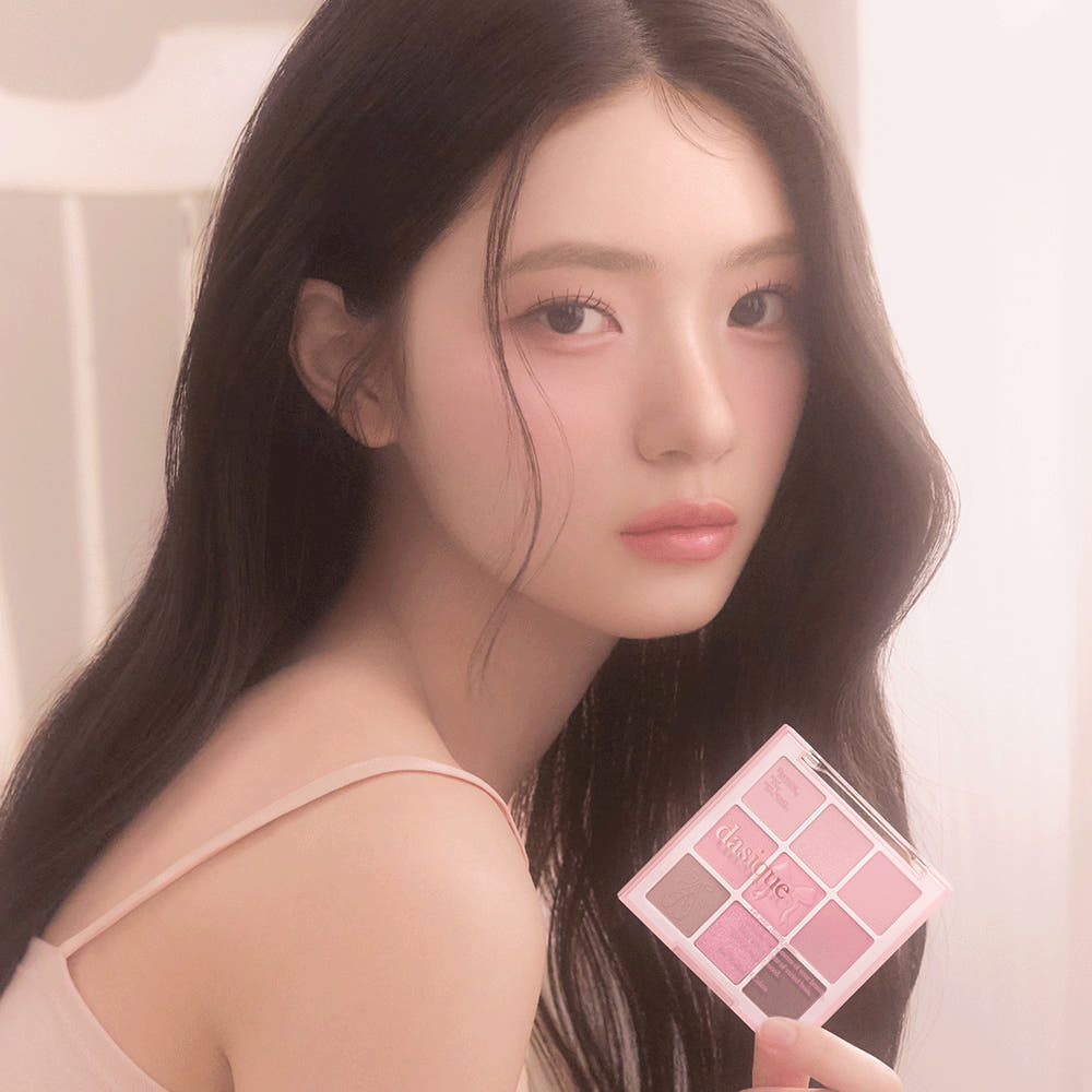 Décris l'image en français : DASIQUE Shadow Palette 8g (#01 - #39) de la marque, palette maquillage tenue par un mannequin.