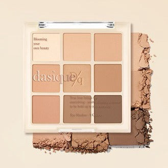 DASIQUE Shadow Palette 8g (#01 - #39), palette de fards maquillage beige et brun sur fond crème avec poudre étalée.