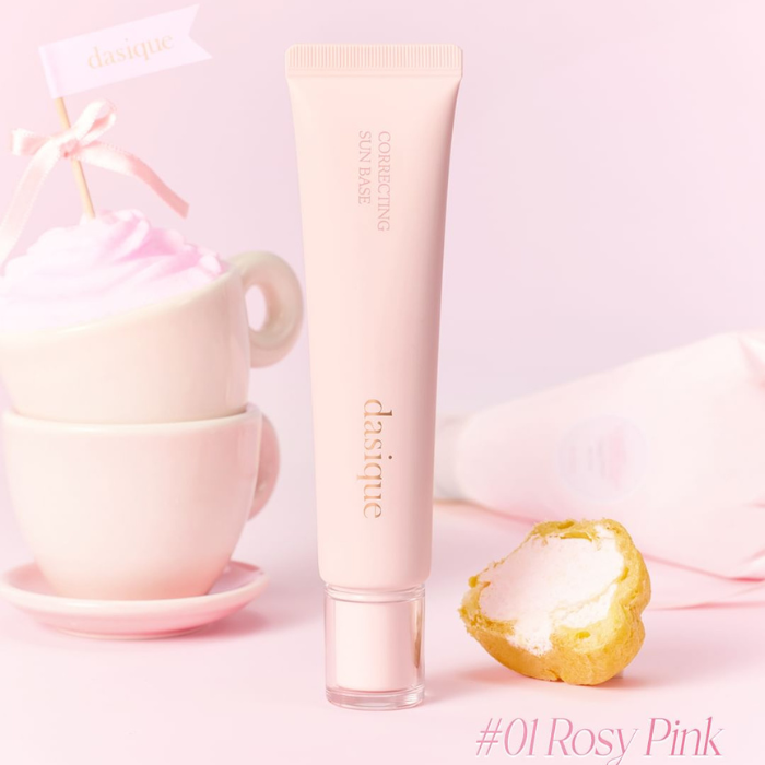 DASIQUE Correcting Sun Base 30ml de la marque DASIQUE, tube beige sur fond rose pastel avec tasse et biscuit