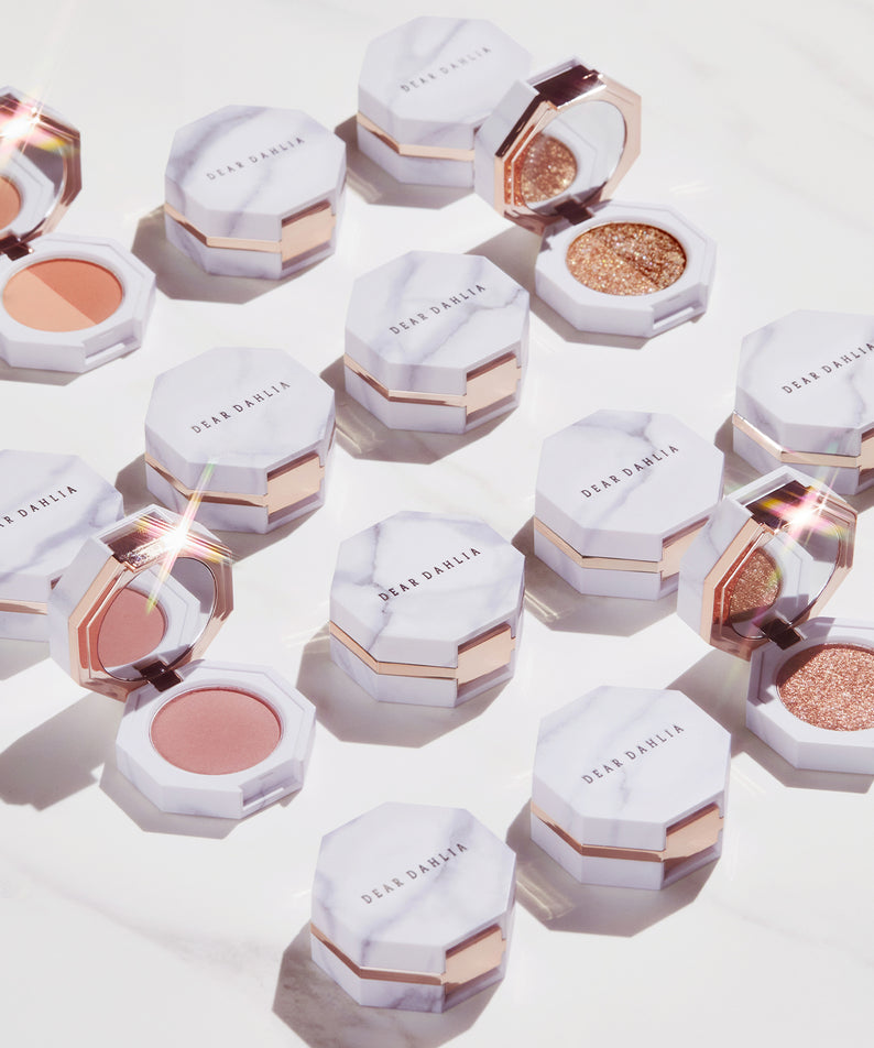 Palette de maquillage DEAR DAHLIA Paradise Dual Palette en teintes variées, présentation luxueuse et éclat irisé.