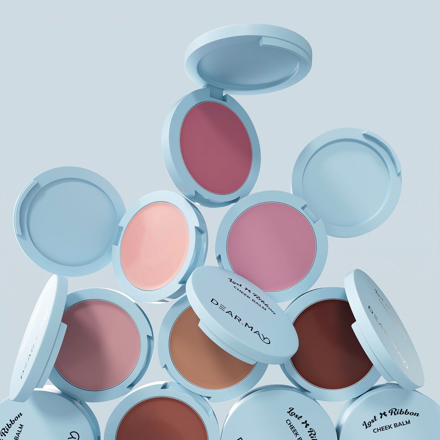 DEAR MAY Lost Ribbon Check Balm de DEAR MAY, visuel packaging bleu avec baumes colorés ouverts sur fond clair.