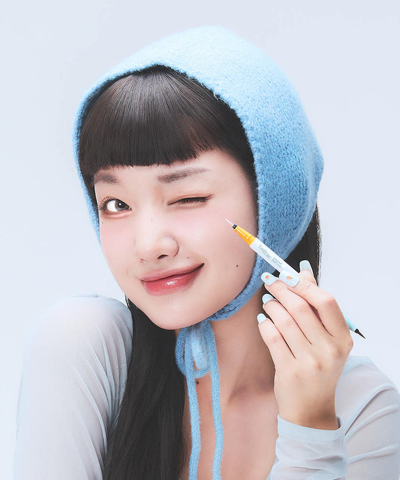 DEAR MAY Tangerine Aegyo-sal Dual Liner de DEAR MAY, maquillage d’une femme avec eyeliner orange, tête et main en gros plan