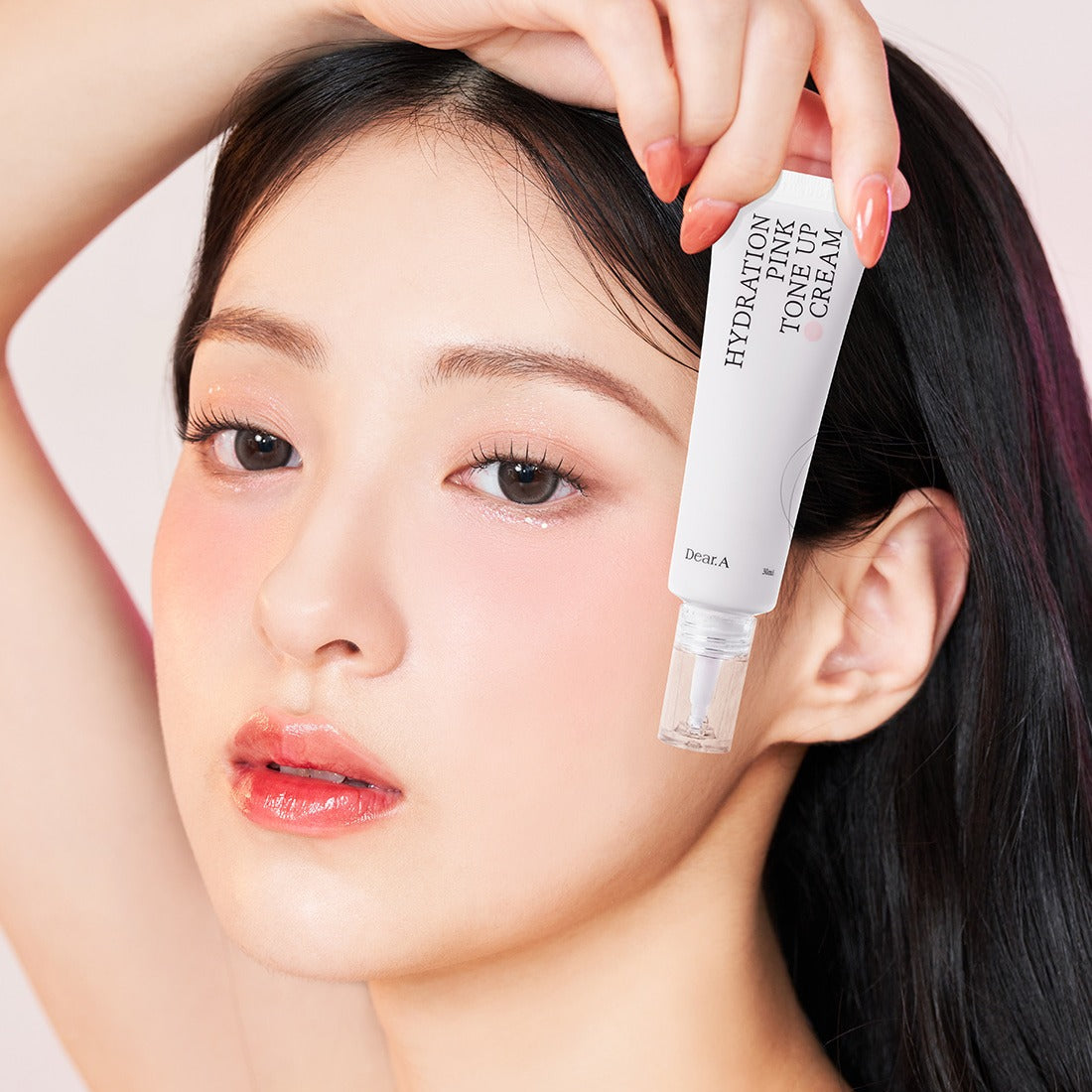 DEAR.A Hydration Pink Tone-Up Cream 30ml, la marque DEAR.A en tube rose, pose maquillage avec main sur visage, contexte beauté.