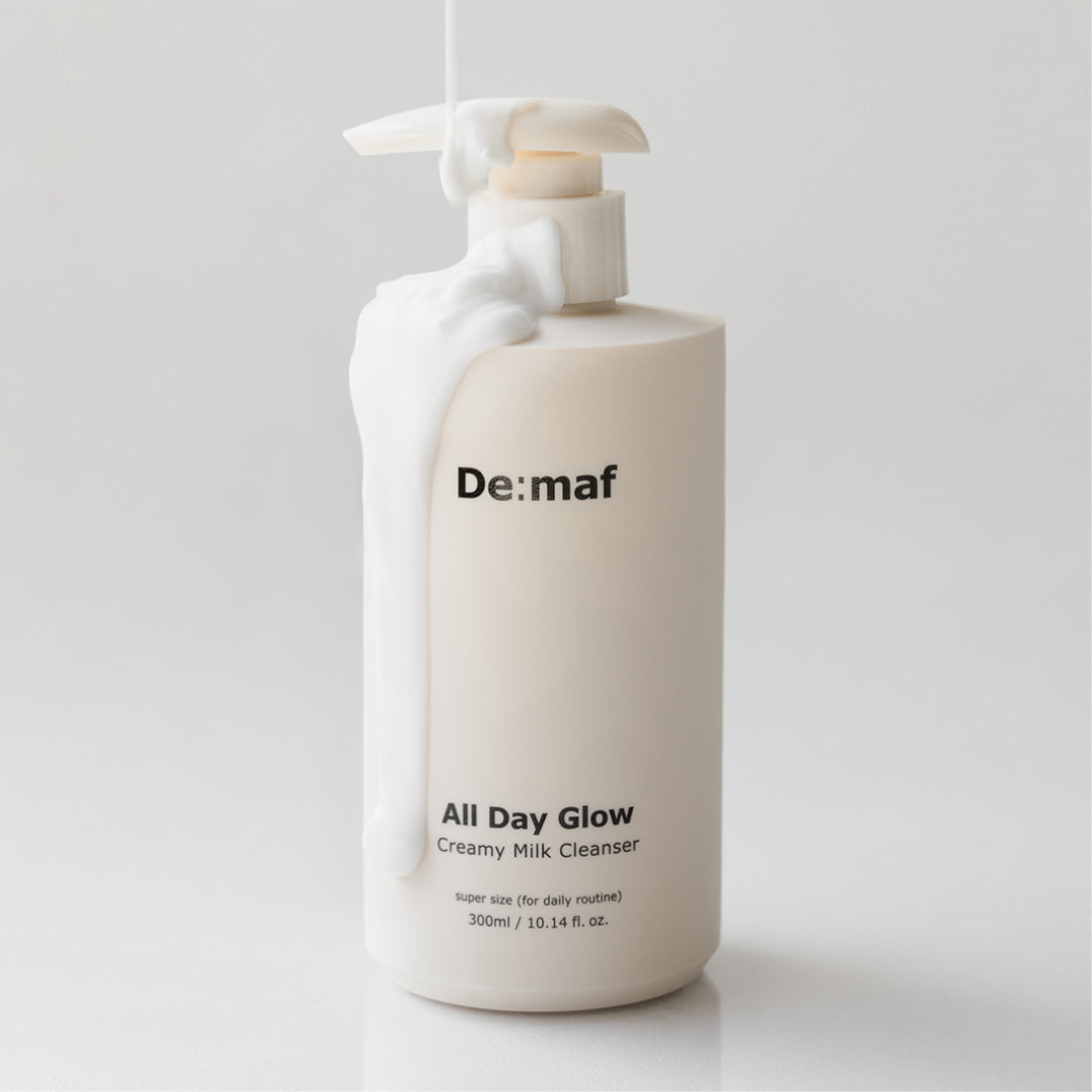 DE:MAF All Day Glow Creamy Milk Cleanser 300ml de De:maf, flacon blanc sur fond clair, pompe et texture crème