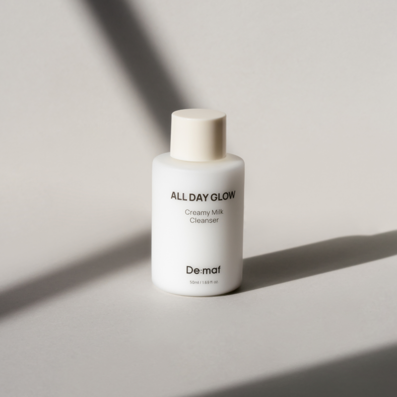 DE:MAF All Day Glow Creamy Milk Cleanser 50ml de De:maf, flacon de nettoyant visage sur fond minimaliste clair.