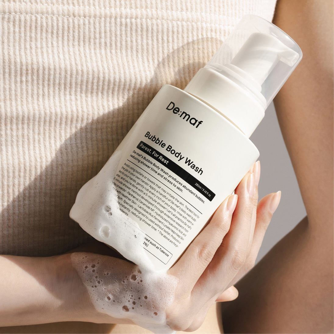DE:MAF Forest Bubble Body Wash 280ml, marque be:maft sur peau, mousse et flacon blanc en salle de bain