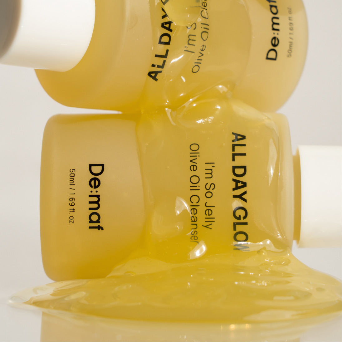 DE:MAF I'm So Jelly Olive Oil Cleanser 50ml de DE:MAF, flacon et gel d’huile d’olive, visuel texture jaune.