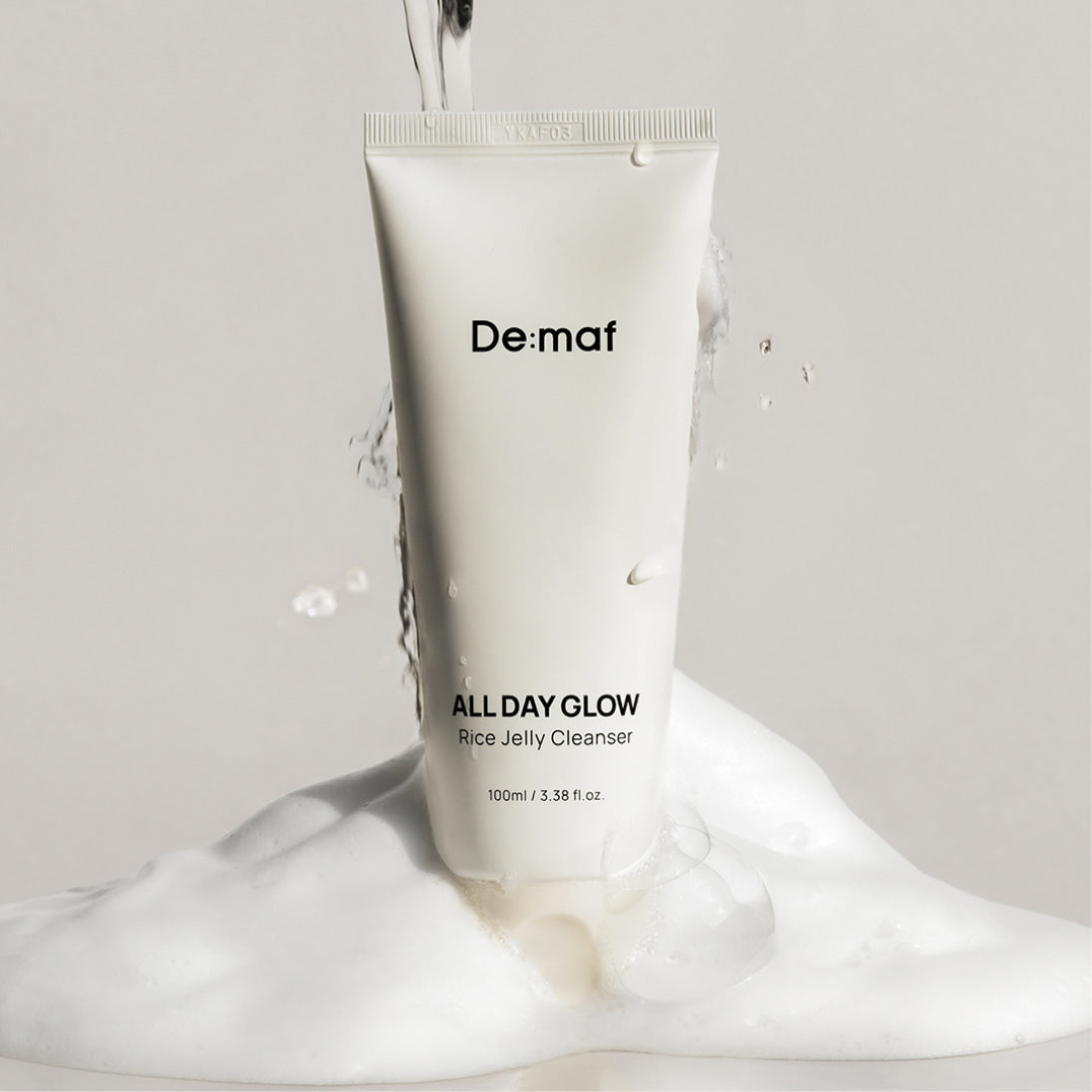 DE:MAF Rice Jelly Cleanser 100ml de la marque De:maf, tube blanc sur fond clair avec texture de nettoyant.