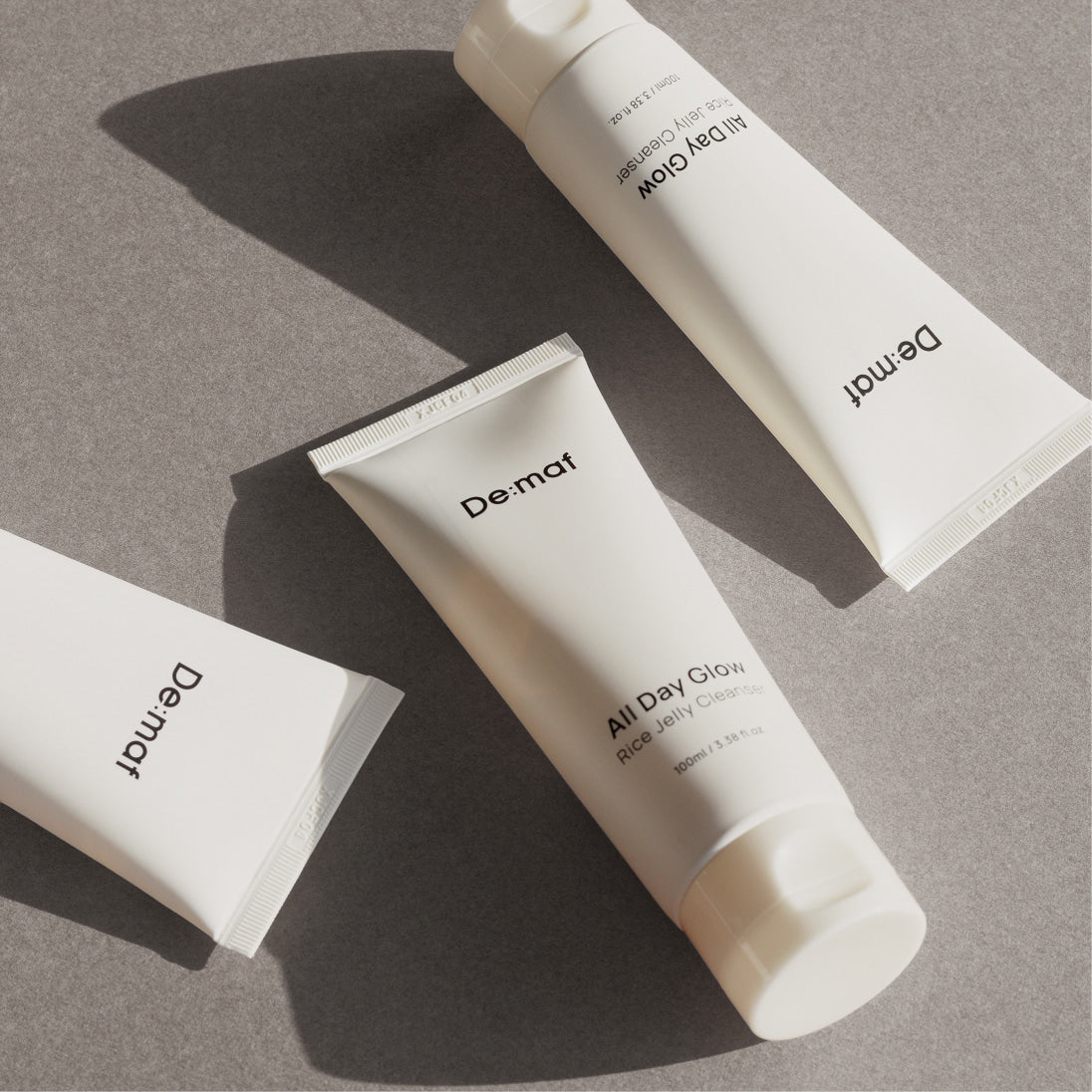 DE:MAF Rice Jelly Cleanser 100ml Dermat, tube sur fond gris, style produit beauté, éclairage naturel