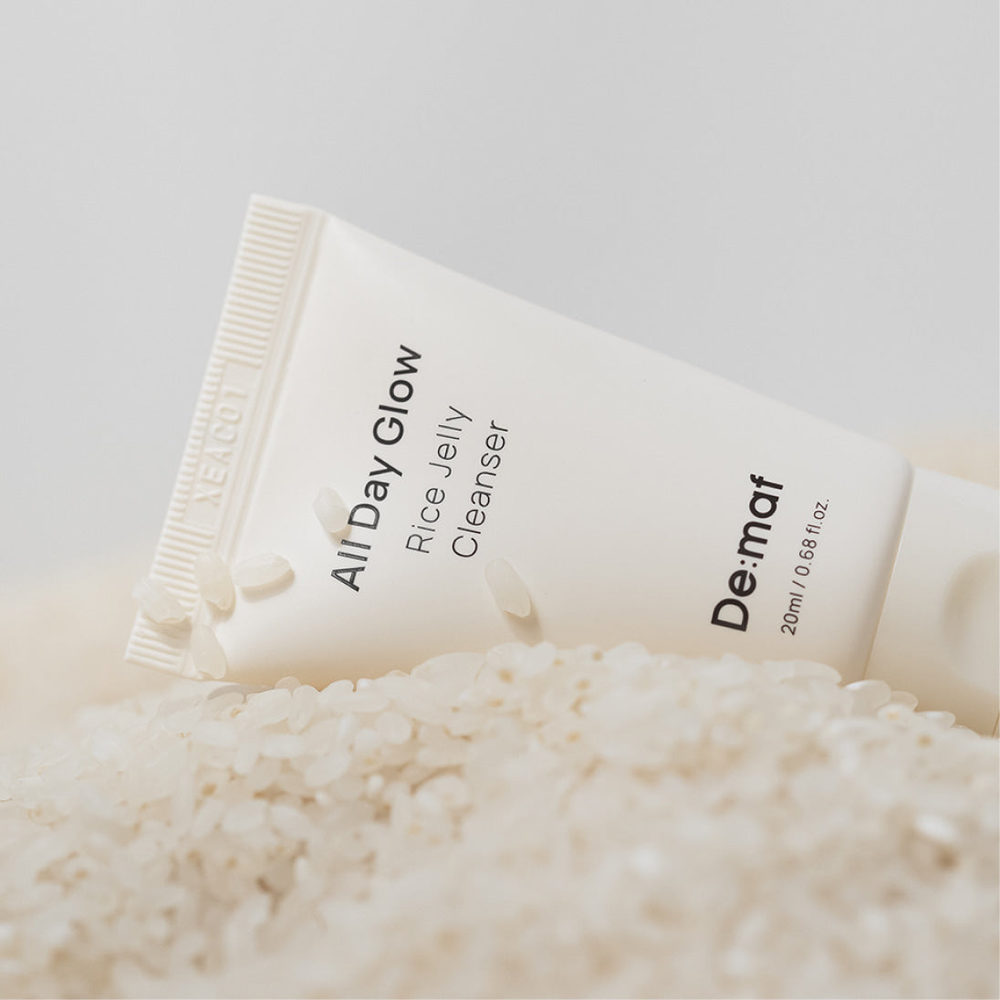 DE:MAF Rice Jelly Cleanser 20ml : marque De-MAF, tube et flocons de riz sur fond clair, contexte produit en gros plan