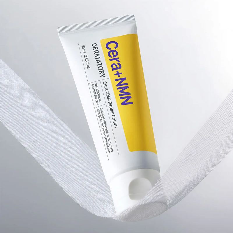 DERMATORY Cera NMN Repair Cream 70ml, tube sur tissu blanc, marque DERMATORY visible, crème réparatrice en contexte beauté