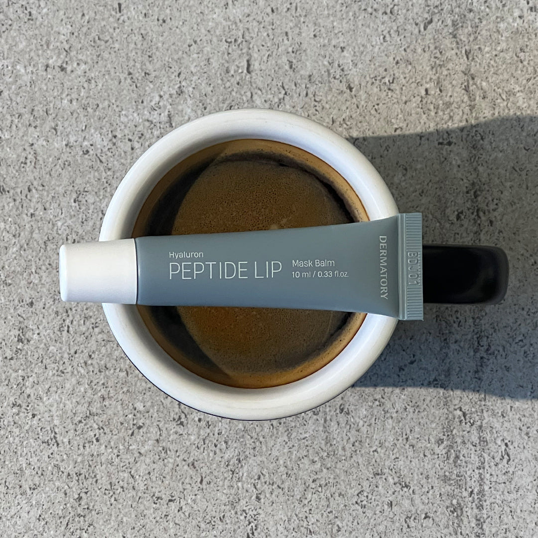 DERMATORY Hyaluronic Peptide Lip Keyring, tube crème pour lèvres sur fond béton, photo produit de la marque DERMATORY.
