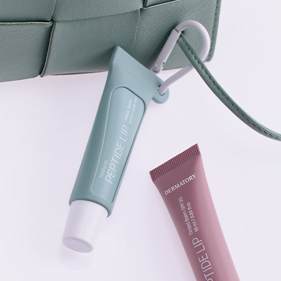 DERMATORY Hyaluronic Peptide Lip Keyring, porte-clés cosmétique sur fond blanc, tubes et attache, marque DERMATORY en vue