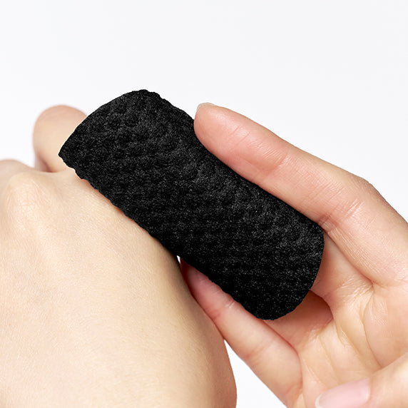 Main tenant une éponge noire dermacare DERMATORY Salicinic Pore Clear Black Pad Refill 30 sheets, marque et recharge
