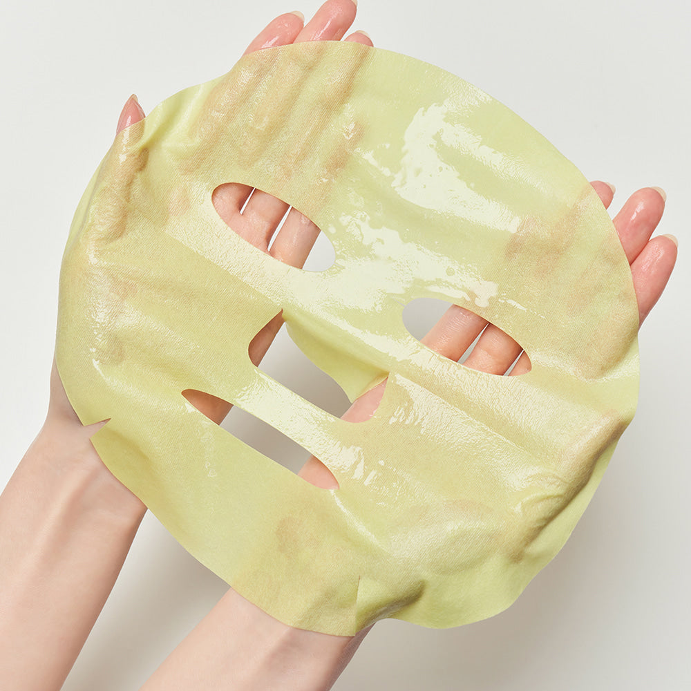 DEWYTREE AC Deep Blemish Calming Mask 10 Sheets : masque en feuille jaune tenu en main, gros plan sur la peau.