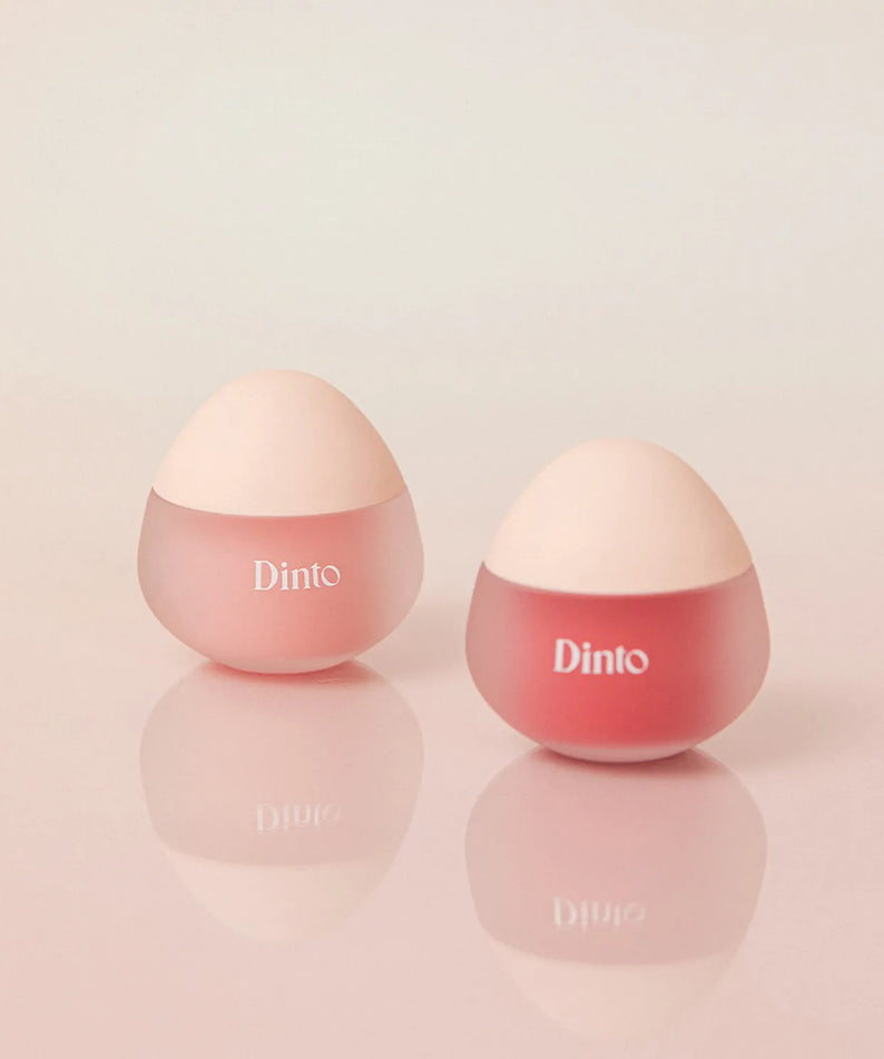 Deux pots de DINTO Chubby Mochi Jelly Popo Lip Mask sur fond rose.