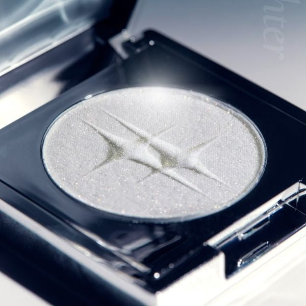 DINTO Polaris Shine Highlighter, gros plan sur la palette avec fard lumineux argenté, fond maquillage studio, marque visible