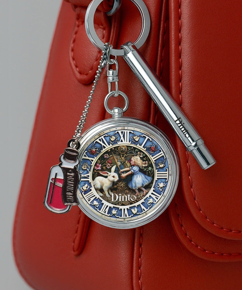 Porte-clés mode avec horloge et motifs à la "DINTO Alice Collection" sur sac rouge, accessoire tendance.