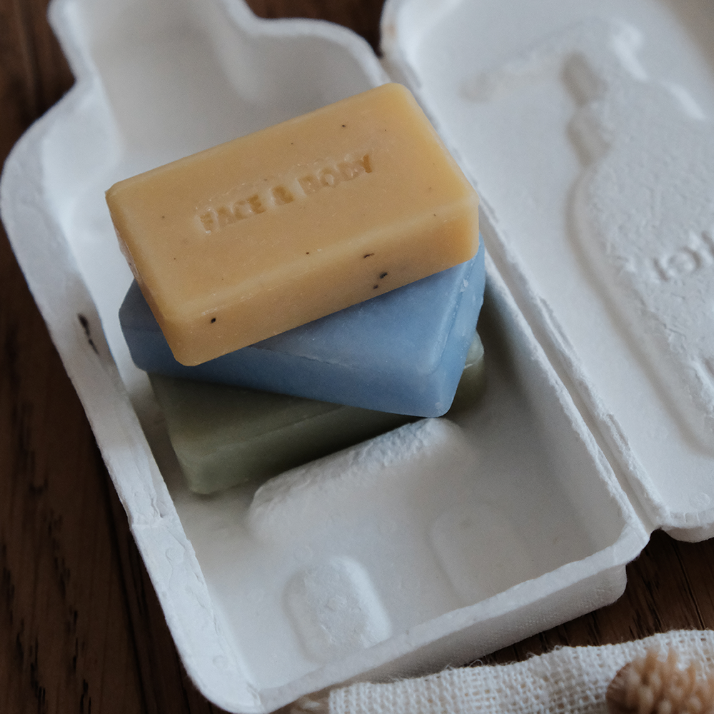 DONGGUBAT Better Than Liquid Travel Kit 60g: savon en pain, marque DONGGUBAT, sur boîtier blanc de voyage, fond bois