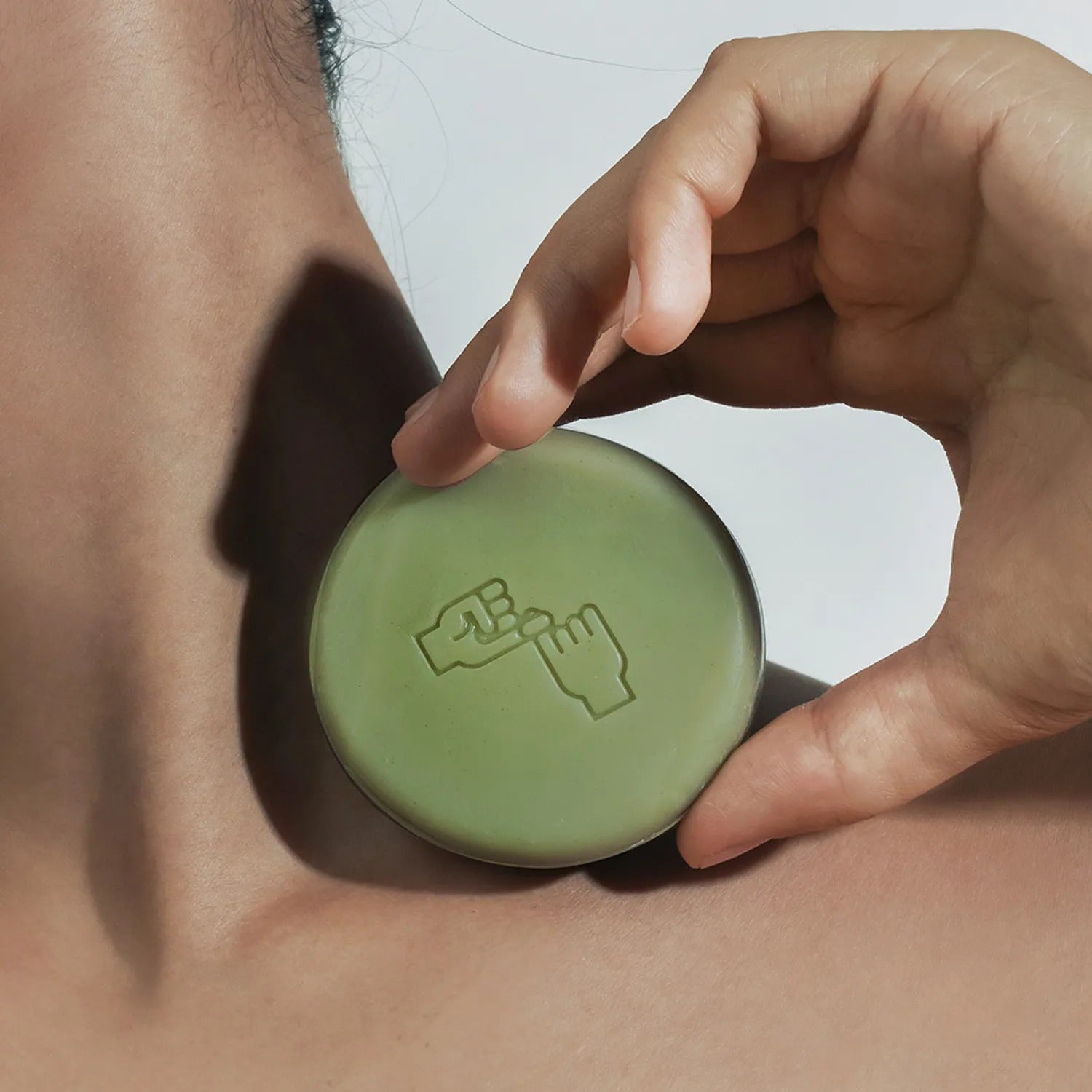 DONGGUBAT Correct Shampoo Bar For Dry Skin, savon solide de marque DONGGUBAT, main tenant une barre verte sur fond blanc.