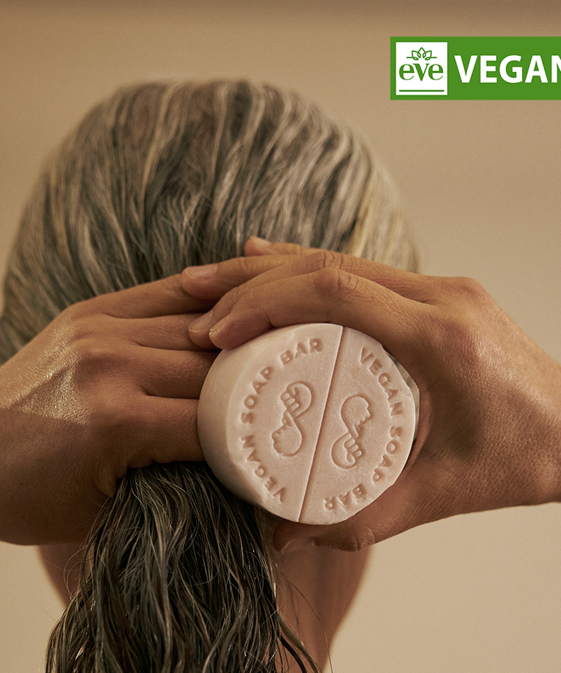 Décrivez l'image : DONGGUBAT Vegan Treatment Bar Dongbaek de la marque DONGGUBAT, main tenant un savon sur fond beige.