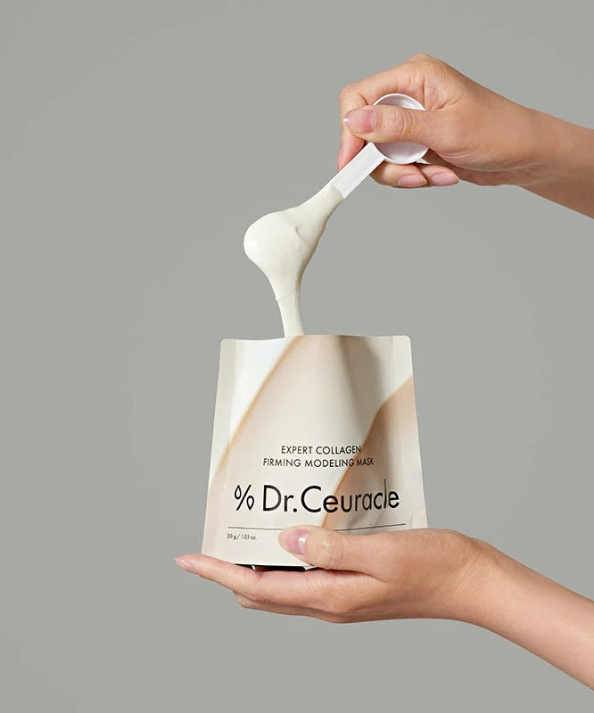 Application du DR.CEURACLE Expert Collagen Firming Modeling Mask 30g avec une spatule dans un emballage élégant.
