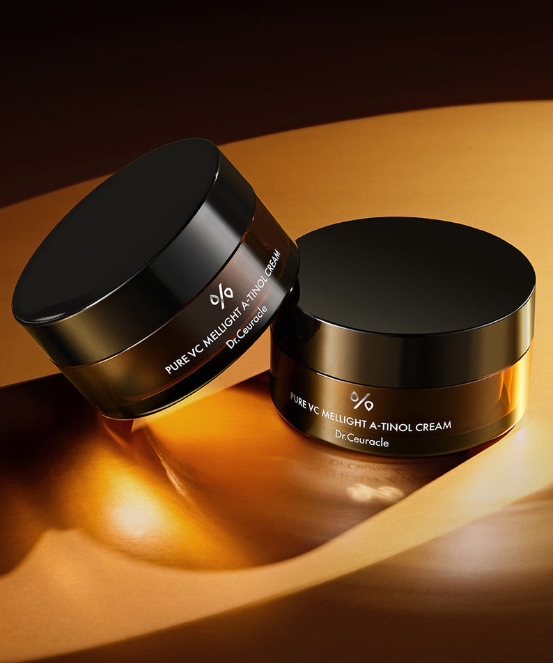 Deux pots de crème DR.CEURACLE Pure VC Mellight A-Tinol Cream 70g sur une surface dorée. Soin de la peau pour une peau éclatante.