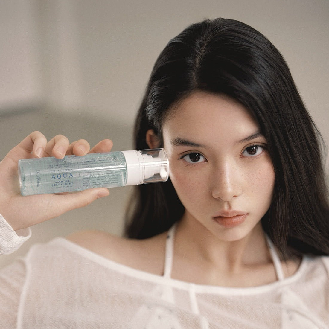 DR.ALTHEA Aqua Marine Jelly Mist 100ml, flacon brumisateur tenue cosmétique, femme appliquant le produit dans une salle de bain
