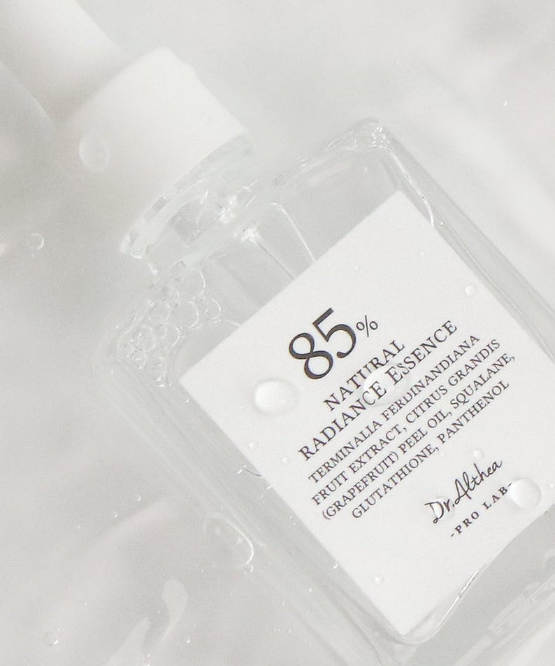 Flacon de 30ml de DR.ALTHEA Natural Radiance Essence sur fond aquatique, 85% d'ingrédients naturels, idéal pour un éclat naturel.