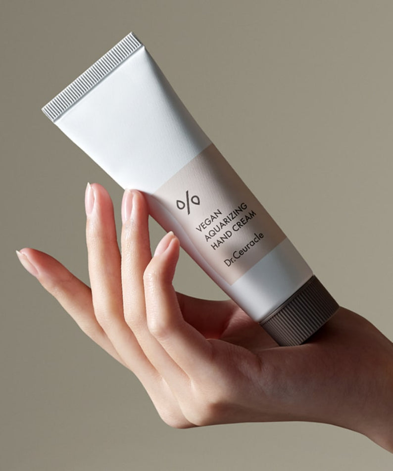 Tube de DR.CEURACLE Aqua Rising Hand cream 50ml tenu en main, crème hydratante pour les mains, 50 ml