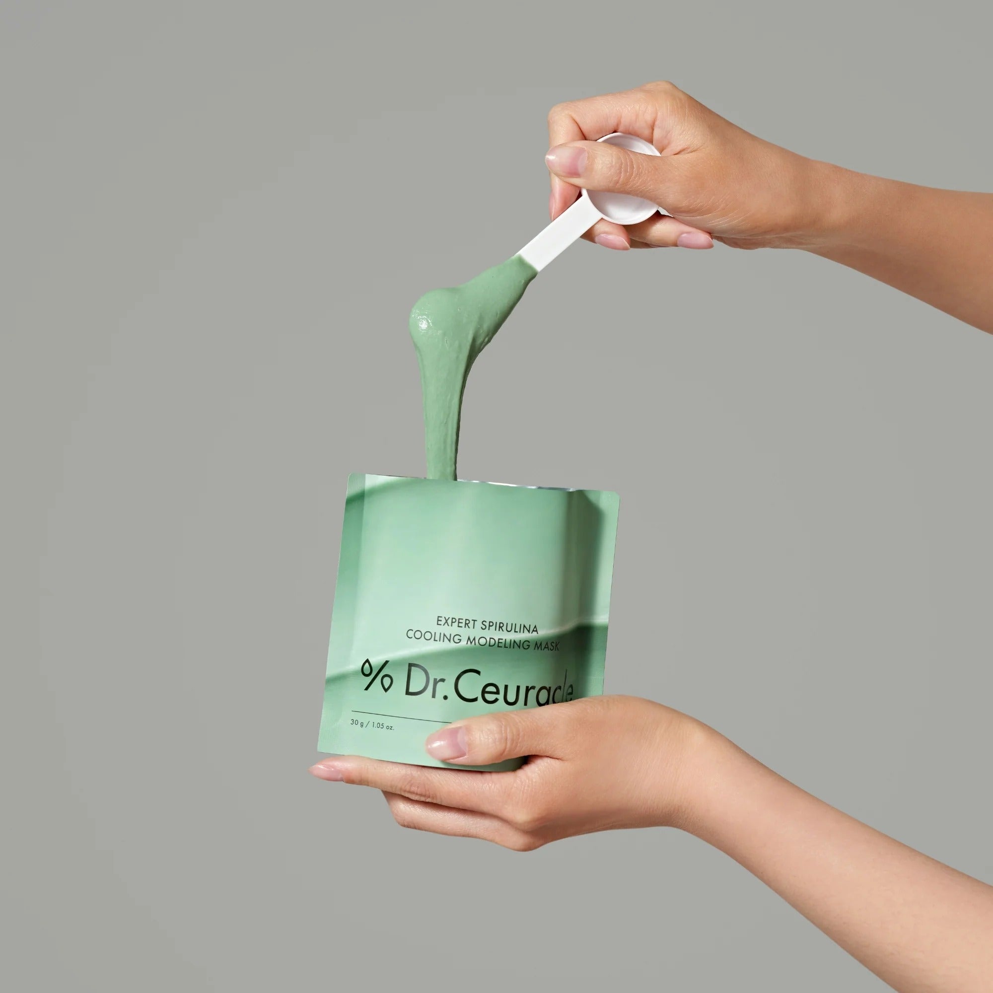 DR.CEURACLE Expert Spirulina Cooling Modeling Mask 30g, marque Dr.Ceuracle : mains tenant un masque vert en gel