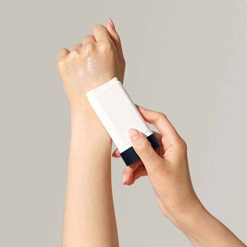 DR.CEURACLE Pro Balance Comfort Sun Stick 18g, marque en stick solaire appliqué sur main, fond clair, photographie produit.