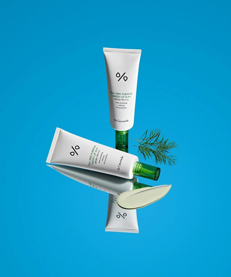 DR.CEURACLE Tea Tree Purifine Green Up Sun 50ml, tube crème avec extrait d’arbre à thé, sur fond bleu.