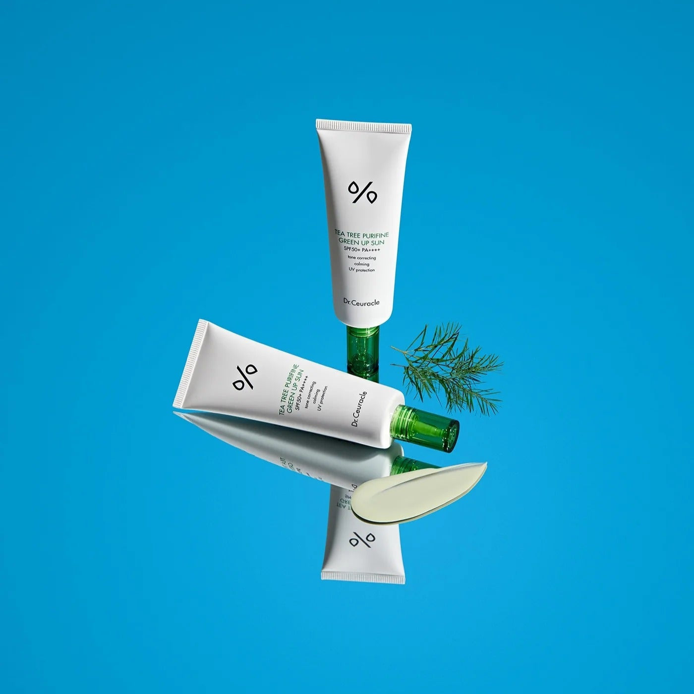 DR.CEURACLE Tea Tree Purifine Green Up Sun 50ml, tube crème avec extrait d’arbre à thé, sur fond bleu.